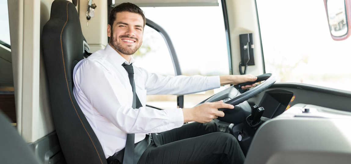 Chauffeur de bus souriant au volant