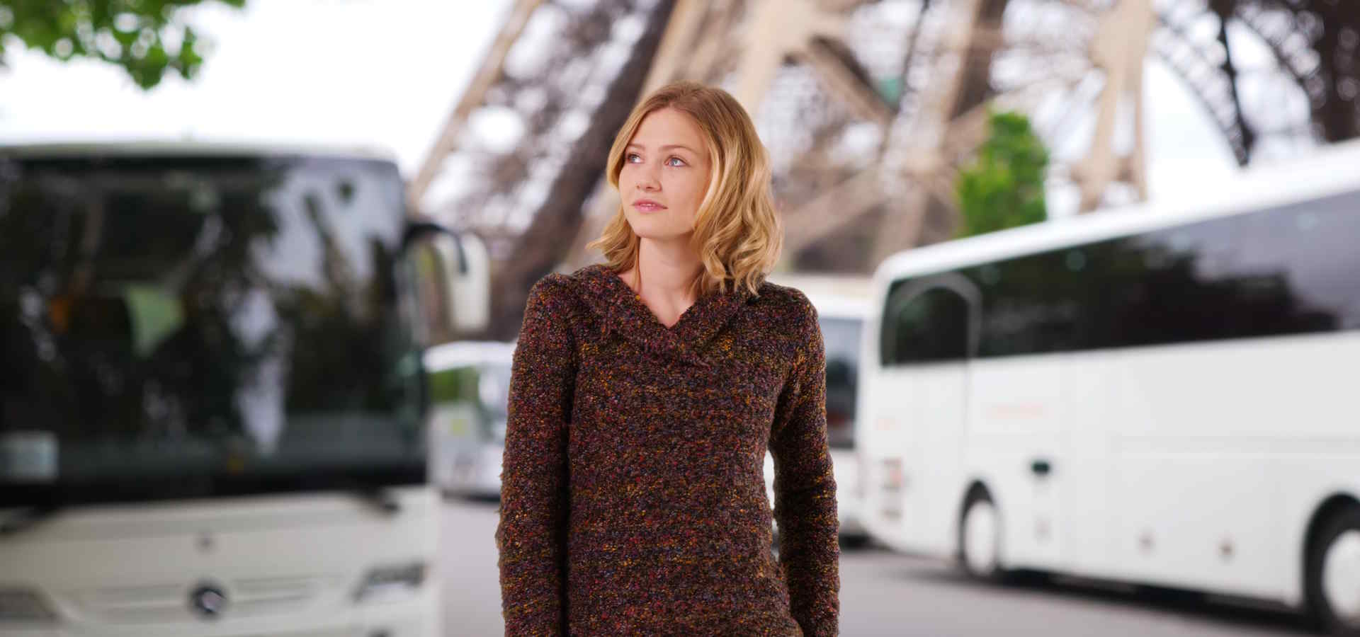 Deux autocars, la tour Eiffel et une passagère devant